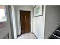 Hallway view with staircase, tile floors, apartment door and a framed picture at 1651 W Oak Ridge Rd # 1651A, Orlando, FL 32809