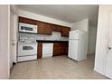 Efficient kitchen featuring ample counter space, white appliances, and tile flooring at 1651 W Oak Ridge Rd # 1651A, Orlando, FL 32809
