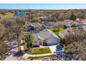 Aerial view of a charming single-Gathering home with lush landscaping and a serene lake nearby at 1701 Knotting Hill Dr, Orlando, FL 32835