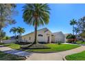 A charming home with a well-maintained lawn, mature palm trees, and a two-car garage at 1701 Knotting Hill Dr, Orlando, FL 32835