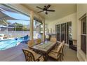 Inviting covered patio with ceiling fan, dining set, and access to a screened-in pool area at 1701 Knotting Hill Dr, Orlando, FL 32835