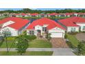 Aerial view of a beautiful home with a red tile roof in a lakeside community at 2335 Symphony Cir, St Cloud, FL 34771
