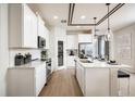 Bright, all-white kitchen features stainless appliances, tile backsplash, and wood-look flooring at 2547 Great Heron Ave, St Cloud, FL 34773