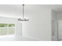 Bright living area featuring sleek, modern chandelier and sliding glass doors to the backyard at 2596 Sw 146 St, Ocala, FL 34473