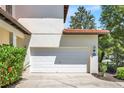 Attached two-car garage with a white door and manicured landscaping at 2840 Roccella Ct, Kissimmee, FL 34747