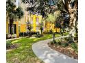 Exterior view of condo building featuring landscaped grounds with walking path at 3368 Robert Trent Jones Dr # 40808, Orlando, FL 32835