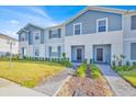 Beautiful townhome exterior featuring a well-maintained lawn and inviting walkways to each unit at 3729 Pacific Ln, Davenport, FL 33897