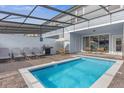 Inviting screened-in pool with patio furniture, grill, and a covered dining area for outdoor relaxation at 3838 Lana Ave, Davenport, FL 33897
