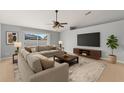 Comfortable living room with a neutral color palette, large sectional, and entertainment center at 408 Magpie Ct, Kissimmee, FL 34759