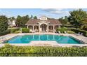 Community pool with stylish clubhouse, lounge chairs, and manicured landscaping at 458 Ellis Square Ct, Sanford, FL 32771