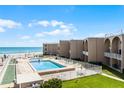 An inviting pool and lounge area with shuffleboard courts offer relaxation and recreation by the beach at 4821 Saxon Dr # 201B, New Smyrna Beach, FL 32169