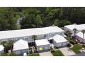 Aerial view of townhome featuring a white roof and attached two-car garage with lush landscaping at 4917 Walden Cir, Orlando, FL 32811