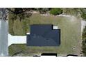 New home with a dark roof and driveway, nestled on a tree-lined street at 5 Fisher Loop, Ocklawaha, FL 32179