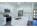 Modern kitchen features stainless steel appliances, white cabinets, and quartz countertops at 5 Fisher Loop, Ocklawaha, FL 32179