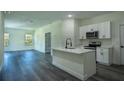 Open-concept kitchen with a large island, stainless appliances, and hardwood floors at 5 Fisher Loop, Ocklawaha, FL 32179