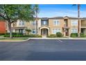 Inviting townhome featuring a beige exterior, manicured landscaping, and an American flag waving near the entrance at 5412 Factors Walk Dr, Sanford, FL 32771