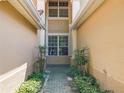 View of walkway to entrance surrounded by mature shrubbery and manicured gardens at 6240 Miramonte Dr # 102, Orlando, FL 32835