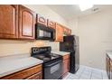 Kitchen with dark wood cabinets, black appliances and light countertops at 6402 Cava Alta Dr # 107, Orlando, FL 32835