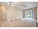 View of the living room featuring carpet, a ceiling fan and sliding glass doors to screened patio at 6402 Cava Alta Dr # 107, Orlando, FL 32835