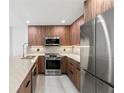 Modern kitchen featuring wood cabinets, stainless steel appliances, and marble countertops at 690 Osceola Ave # 502, Winter Park, FL 32789