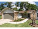 Beautifully landscaped front yard with stone accents and a walkway leading to the entrance of this charming home at 735 Oak Ter, Orange City, FL 32763