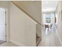 Inviting entryway featuring staircase and view into the dining room at 8969 Stinger Dr, Davenport, FL 33896