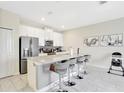 Modern kitchen with white cabinets, stainless steel appliances and a large center island at 8969 Stinger Dr, Davenport, FL 33896