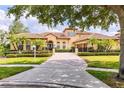 Attractive home features a paver driveway, a meticulously maintained lawn, lush landscaping, and a well-lit two-car garage at 9178 Panzani Pl, Windermere, FL 34786