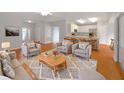 Open-concept living room featuring modern furniture and a seamless transition to the well-lit kitchen at 9665 Se 125Th Ln, Summerfield, FL 34491