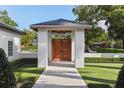 Beautiful custom entryway with modern pergola and custom door design framed by manicured greenery at 1020 Mayfield Ave, Winter Park, FL 32789