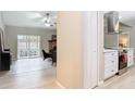 Open-concept living area with wood floors, flowing into a bright kitchen with stainless appliances and white cabinets at 1025 Winter Springs Blvd, Winter Springs, FL 32708