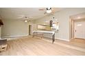 Spacious open-concept living room with wood floors, fireplace, ceiling fans, and a view of the kitchen and front door at 1025 Winter Springs Blvd, Winter Springs, FL 32708