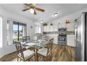 Eat-in kitchen featuring stainless steel appliances, white cabinets, and glass-top dining table at 1065 Jason Ridge Ct, Kissimmee, FL 34747