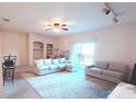 A spacious living room with plush seating, ample light, and a ceiling fan that adds a cozy touch at 107 Vista Verdi Cir # 237, Lake Mary, FL 32746