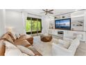 Comfortable living room featuring built-in shelving, a large sectional, and access to the outdoor patio at 132 Rosa Bella Vw, Debary, FL 32713