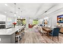 Open-concept living room and kitchen with a large island, modern lighting, and hardwood floors at 132 Rosa Bella Vw, Debary, FL 32713