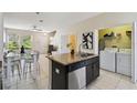 Bright kitchen with an island, seating, and laundry area at 14090 Avenue Of The Groves, Winter Garden, FL 34787