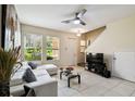 Bright living room features a white sectional, modern ceiling fan, and ample natural light from large windows at 14090 Avenue Of The Groves, Winter Garden, FL 34787