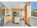 Bright kitchen features stainless steel appliances, light wood cabinets, and a movable island at 1425 Chatfield Pl, Orlando, FL 32814