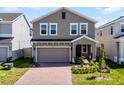 Attractive two-story home featuring a brick driveway, tidy lawn and an attached garage at 14613 Erice Ave, Clermont, FL 34714