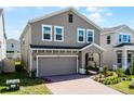 Two-story house with brick driveway, attached garage, and a front yard at 14613 Erice Ave, Clermont, FL 34714