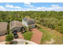Birds eye view of home with solar panels, brick driveway, manicured lawn, and mature trees at 1559 Scrub Jay Ct, Deland, FL 32724