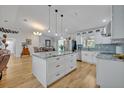 Spacious white kitchen with large island featuring granite countertops and modern stainless steel appliances at 1621 Highland Dr, Longwood, FL 32750