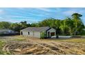 Home's backyard with land and driveway leading up to the 2 car garage at 170 Blaine St, Eustis, FL 32726