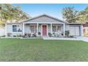 Charming home with a covered front porch, classic rocking chairs, and beautiful landscaping at 1905 Lady Ave, Ocoee, FL 34761