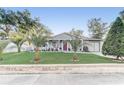 Inviting home with a lush green lawn, beautiful palm trees, and charming curb appeal at 1905 Lady Ave, Ocoee, FL 34761