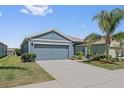 Charming single-story home with a well-maintained lawn, mature landscaping, and an attached two-car garage at 2907 Sime St, New Smyrna Beach, FL 32168