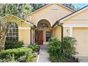 Inviting home entrance framed by lush landscaping and featuring a stylish red front door at 2987 Sabel Oak Pl, Oviedo, FL 32765