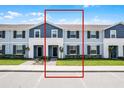 Charming two-story townhome with blue accents, black shutters, and well-maintained landscaping at 301 Jetty Way, Davenport, FL 33897