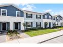 Exterior view of townhomes featuring blue siding, manicured lawns, and well-maintained landscaping at 301 Jetty Way, Davenport, FL 33897